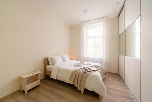a white bedroom with a bed and a window at Bright 73m2 Apartment - Blaumana Street Central in Riga