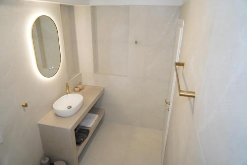 a white bathroom with a sink and a mirror at Villa Noema Kineta in Kineta