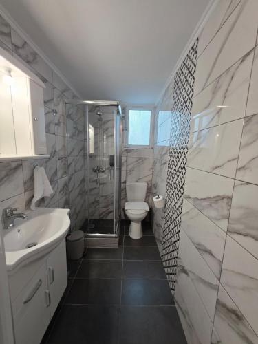 a bathroom with a toilet and a sink and a shower at SeDi Cozy Apartment in Chios