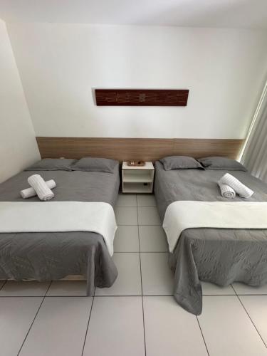 two beds sitting next to each other in a room at Iloa Residence V13 Beach - localização privilegiada in Barra de São Miguel
