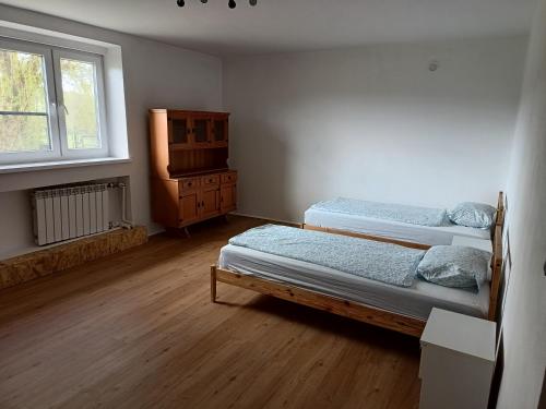 a bedroom with two beds and a dresser and a window at Penzion Iris in Albrechtice
