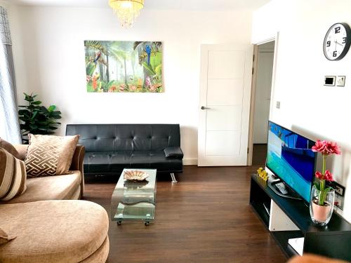 a living room with a couch and a tv at 2-Bedrooms Modern Apartment next to Velodrome, Lounge, Balcony, Parking, ABBA in London