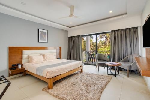 a bedroom with a bed and a living room at asar Upper House Morjim Beach by Orion Hotels in Morjim
