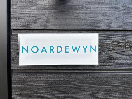 a sign on a wooden door with the word noyardfw at Noardewyn - Ecohuisjes Terschelling in Midsland