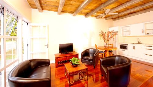 a living room with two leather chairs and a table at Seaport Village in Russell