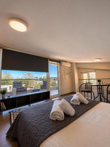 ein Schlafzimmer mit einem großen Bett, auf dem Handtücher liegen in der Unterkunft Enervillas 2030 in Káto Achaḯa