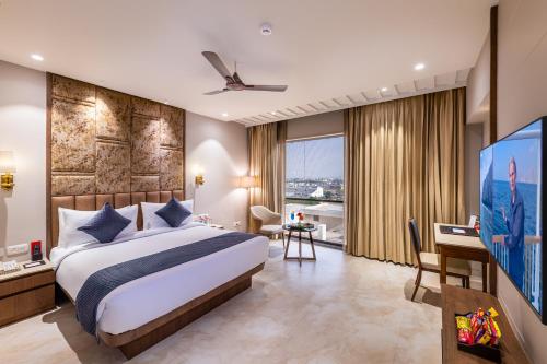 a bedroom with a large bed and a flat screen tv at SkkyLight Lords Inn Nanded in Nānded
