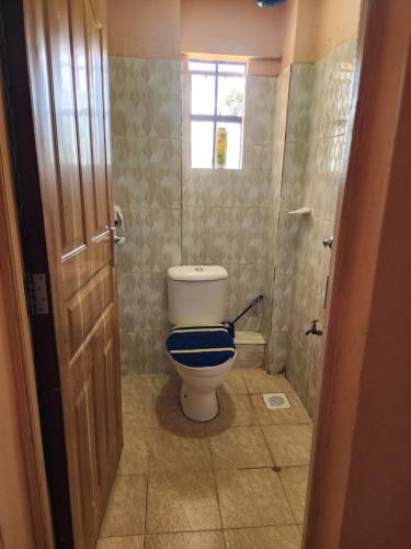 a bathroom with a toilet and a window in it at Pure excellence homes in Ruiru