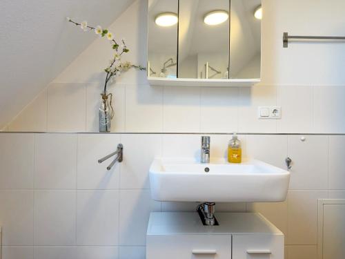 a white bathroom with a sink and a mirror at 1006 - Haus Seesternweg in Dahme