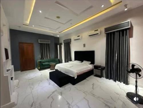 a large bedroom with a bed and a green couch at Jolie Homes in Lekki