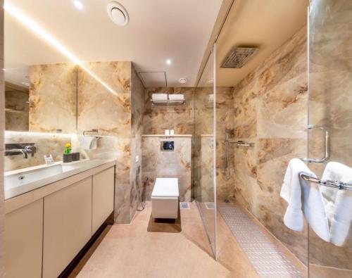 a bathroom with a shower and a toilet and a sink at SkkyLight Lords Inn Nanded in Nānded
