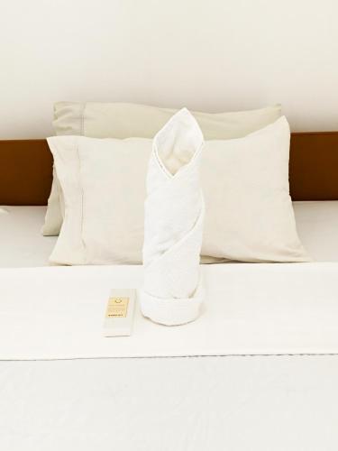 a white bed with white pillows and a towel at A & L Resort - Sea & Mountain View in Looc