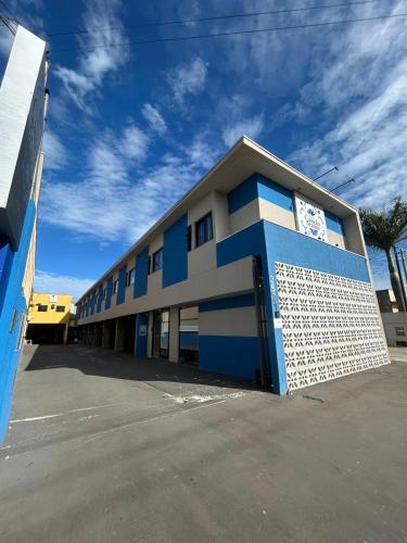 a blue and white building with a parking lot at Hotel Castelo Branco in Arapongas