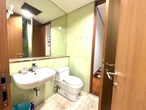 a bathroom with a toilet and a sink and a mirror at Soho Suites Kualalampur by homestay klcc in Kuala Lumpur