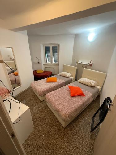 a room with two beds with orange pillows on them at Tramonto in Mele