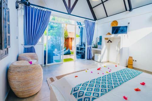 a bedroom with blue curtains and a bed in a room at Villa on Air in Gili Islands