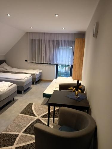 a room with two beds and a table and chairs at Port Bobięcino in Bobięcino