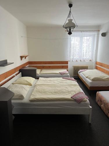 a bedroom with three beds in a room at Zlatá Stezka in Modrava