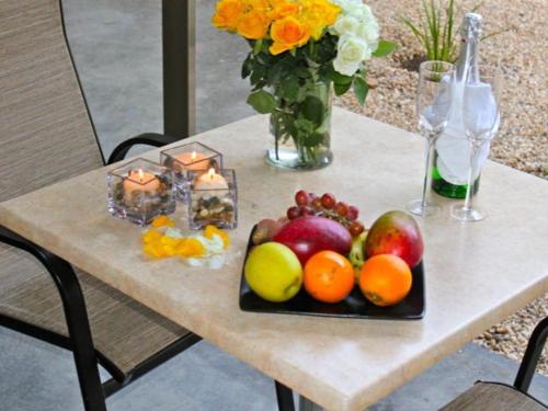 a table with a tray of fruit and candles on it at Monte Bello Guesthouse in Windhoek