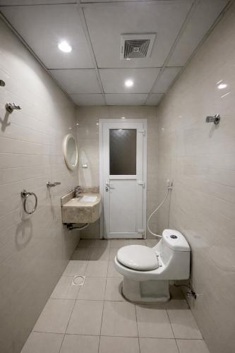 a bathroom with a toilet and a sink at Elsafa Hotel in Salalah