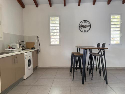 a kitchen with a table and chairs and a washing machine at Villa Serenity in Les Abymes