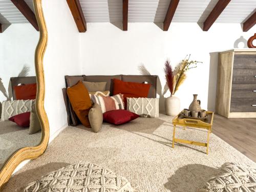 a room with a couch with pillows and a mirror at Villa Serenity in Les Abymes