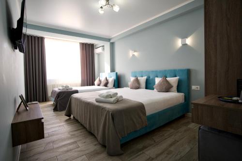 a hotel room with two beds and a window at Hotel Paris & SPA in Chişinău