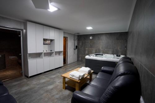 a living room with a black leather couch and a table at Hotel Paris & SPA in Chişinău