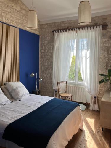 a bedroom with a large bed and a window at La Cachette de Beaumont in Marsais