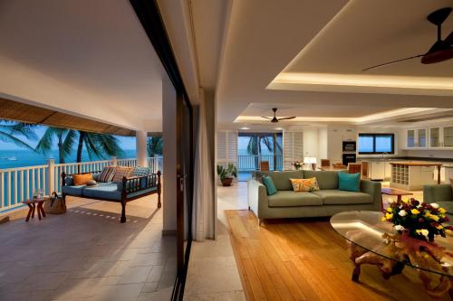 a living room with two couches and a kitchen at Hemingways Watamu in Watamu