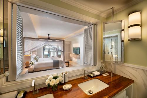 a bathroom with a large window above a sink at Hemingways Watamu in Watamu