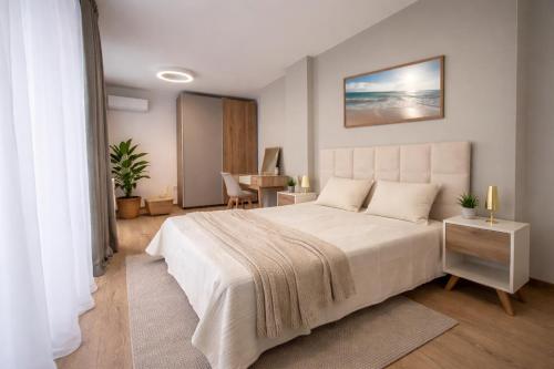a bedroom with a large bed and a table at SoleMare Luxury 2 Bedroom Apartment in Aheloy