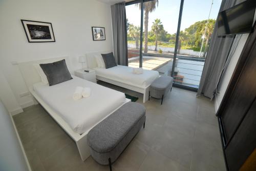 a hotel room with two beds and a balcony at Villa Alvor in Alvor