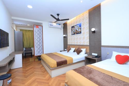 a hotel room with two beds and a red heart on the wall at Thendral inn in Vellore