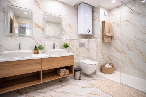 a bathroom with two sinks and a toilet at SoleMare Luxury 2 Bedroom Apartment in Aheloy