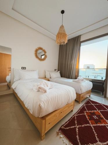 a bedroom with two beds and a large window at Swellora Surf Camp Imsouane in Imsouane