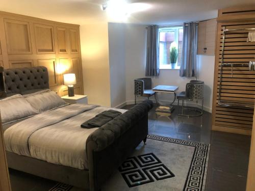a bedroom with a bed and a table and a desk at Hendham House - Near Etihad Stadium, CoOp Live Arena, AO Arena, Piccadilly Train Station & Manchester City Centre in Manchester