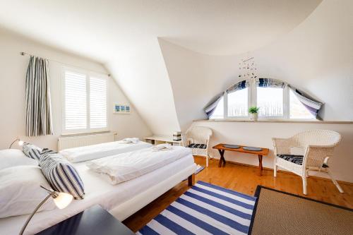 a bedroom with two beds and a table and chairs at Haus Arrewind in Ahrenshoop