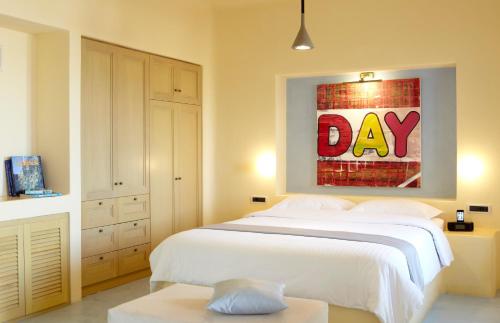 a bedroom with a bed with a day painting on the wall at Voreina Gallery Suites in Pirgos