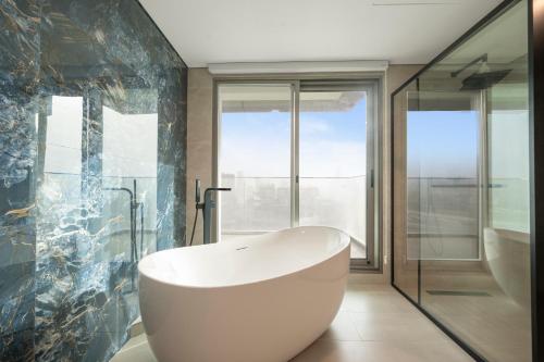 a bath tub in a bathroom with a window at Tranquil Wellness Tower By Wellcube in Dubai
