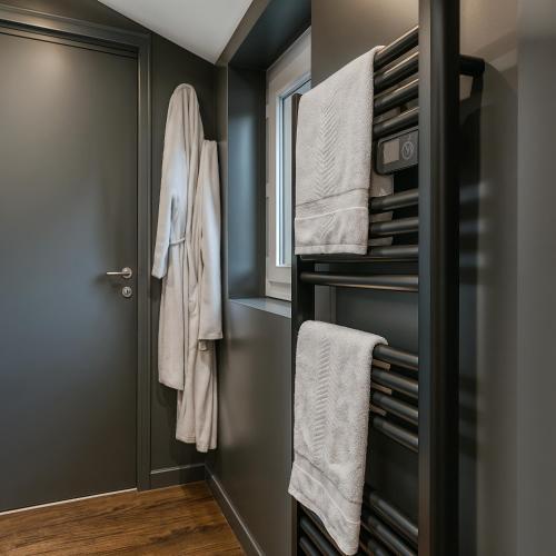a bathroom with towels hanging on a door at Suite Phoenix - Maison Cosy avec Terrasse & Cinéma Privé in Angoulême