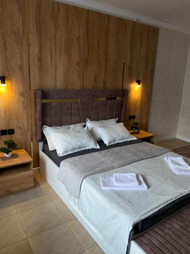 a bedroom with a large bed and two tables at AIDANA гостиница in Oral