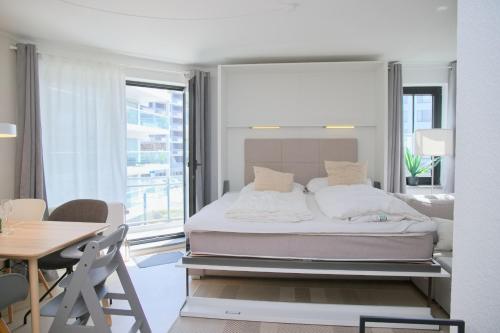 a bedroom with a bed and a table and a desk at Haus Titania App 9 inkl WLAN in Grömitz