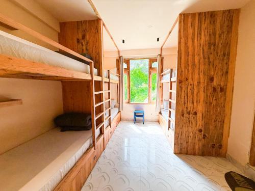 a room with two bunk beds and a hallway at Grham Hostel & Cafe Kasol, Katagla in Kasol