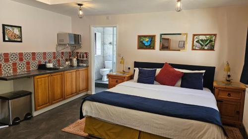 a bedroom with a large bed and a kitchen at Conifers Guest House in Oxford