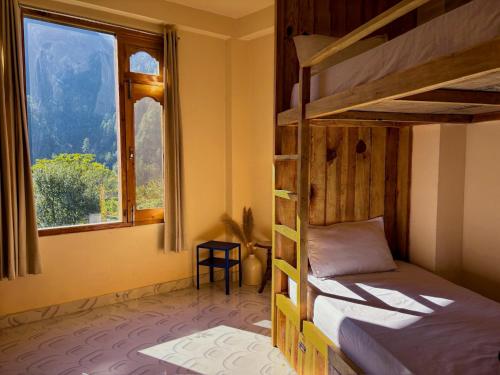 a bedroom with two bunk beds and a window at Grham Hostel & Cafe Kasol, Katagla in Kasol