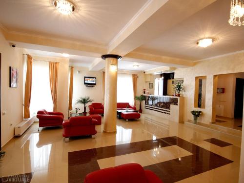 a large living room with red chairs and a fireplace at 3 Stejari Brasov in Braşov