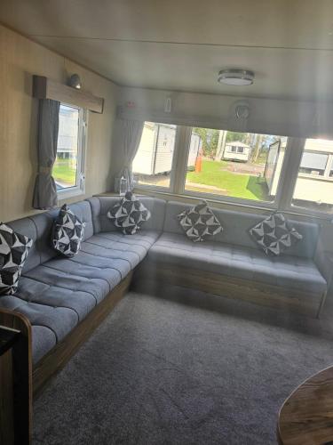 a couch in a living room with pillows on it at Haggerston Castle Towerlawn 50 in Cheswick