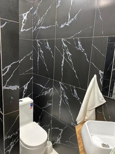 a bathroom with a white toilet and a sink at AIDANA гостиница in Oral