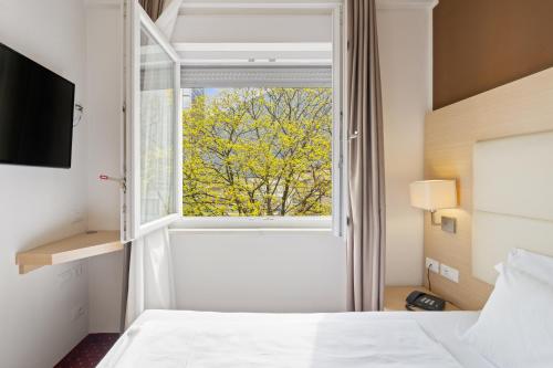 a bedroom with a bed and a window at Hotel Regina in Bolzano
